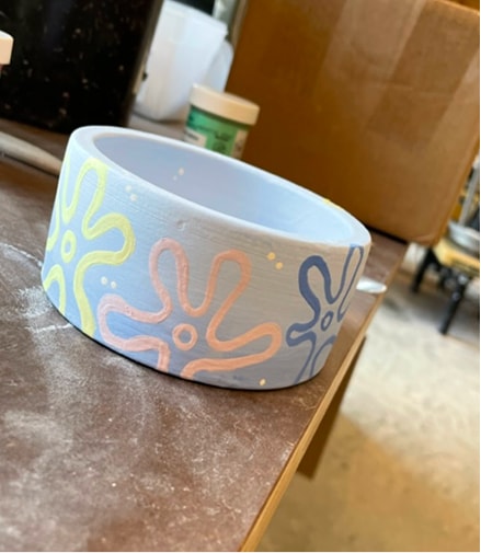 A ceramic bowl hand-painted with a colourful floral pattern.